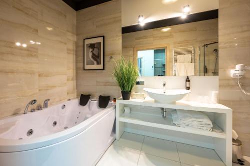 卢布林Hotel Atelia的一间带大浴缸和水槽的浴室
