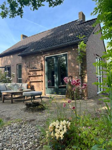 EwijkHuisje Hygge - luxe bungalow met grote tuin的砖房,前面有长凳