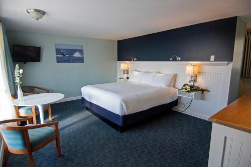 普罗温斯敦开普殖民旅馆的酒店客房,配有一张床、一张桌子和椅子