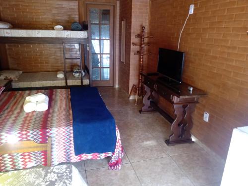 卢米亚Pousada luar da serra的客厅配有电视和书桌及电视