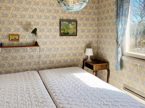 DalaröHoliday home DALARÖ II的一间卧室配有一张床、一张桌子和一个窗户。