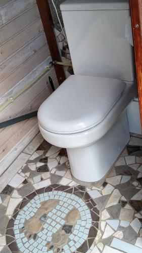 斯泰厄Cosy Farmhouse Glamping的浴室设有卫生间,铺有瓷砖地板。