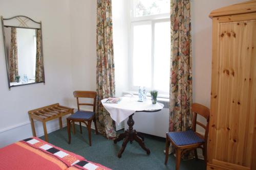 弗莱堡Pension Waldheim的客房设有桌椅和窗户。
