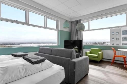 雷克雅未克Icelandic Apartments by Heimaleiga的一间设有两张床、一张沙发和一把椅子的房间