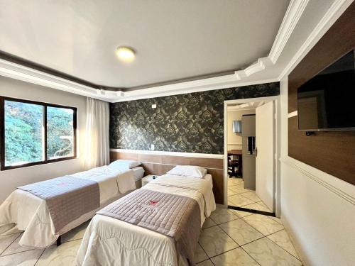 伊瓜苏芬尼斯酒店 的一间设有两张床和电视的房间
