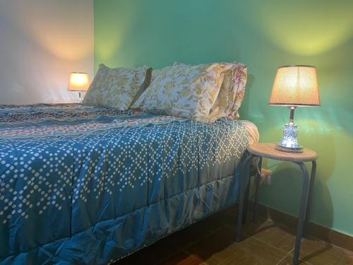 圣多美Tropical Paradise的一间卧室配有一张床和一张桌子上的台灯