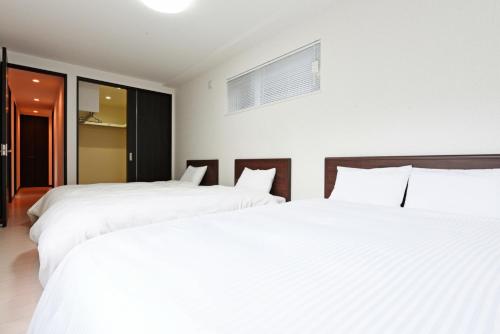 札幌Sapporo - House - Vacation STAY 14578的配有白色床单的酒店客房内的两张床