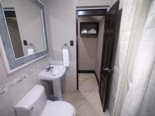 危地马拉L´Aurora Inn hostal的一间带卫生间、水槽和镜子的浴室