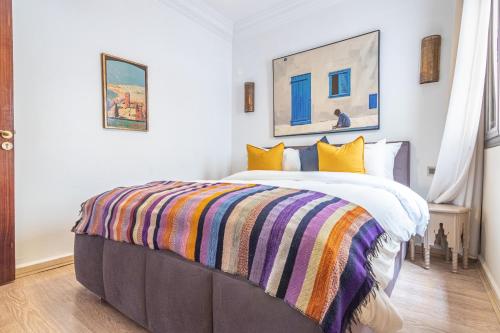 马拉喀什Caprice palace hivernage的一间卧室配有一张带彩色毯子的床