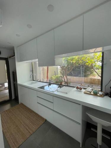 阿纳维索斯Charming Coastal Retreat的白色的厨房设有水槽和窗户