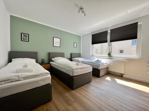雷姆沙伊德Sali - R1 - Apartmenthaus, WLAN, TV的一间卧室设有两张床和窗户。