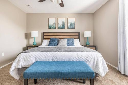 布兰森3BR Branson Condo PrimeLocation!的一间卧室配有一张大床和蓝色的搁脚凳