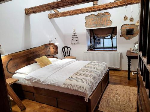 波卢巴库苏斯Joyard - Pensiune & Parc的一间卧室配有一张大床和木制床头板