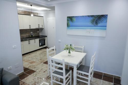 维利波吉Fishta apartments Q5 34的厨房以及带白色桌椅的用餐室。
