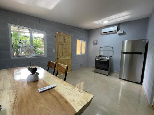 TamaniqueHostal Camila’s的厨房配有桌子和不锈钢冰箱。