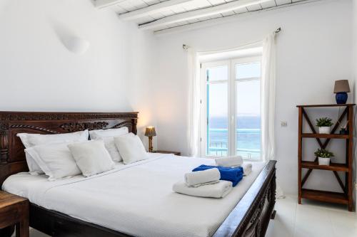 圣爱奥尼斯米科诺斯Salty Blè的卧室配有带白色枕头的床和窗户。