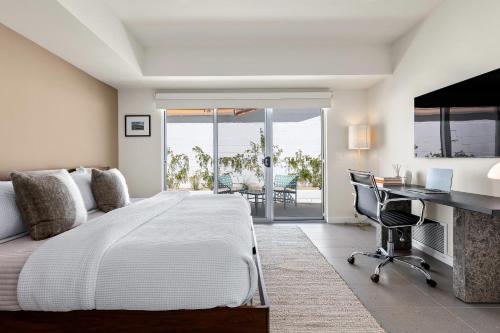 棕榈泉Desert Orchid Retreat的一间卧室配有一张大床、一张桌子和一张书桌