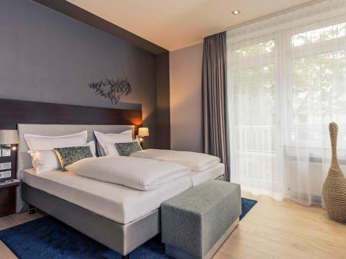 科隆美居科隆贝佛斯特拉瑟酒店的一间卧室设有一张大床和一个大窗户