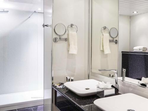 圣海伦斯Mercure St Helens的白色的浴室设有水槽和淋浴。