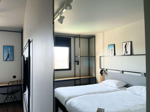 吕内尔Ibis Lunel Petite Camargue的酒店客房设有两张床和窗户。