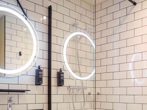 吕内尔Ibis Lunel Petite Camargue的浴室内设有带两面镜子的淋浴
