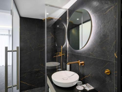 托考伊Mercure Tokaj Center的一间带卫生间和镜子的浴室