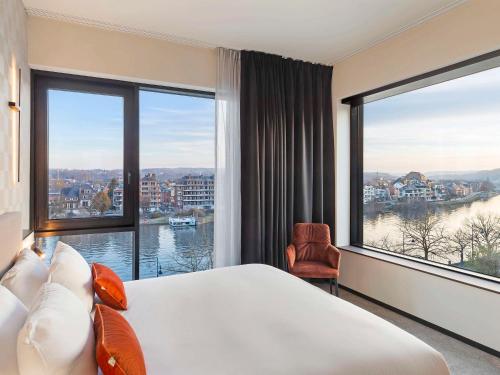 那慕尔Mercure Namur Hotel的酒店客房设有一张大床和大窗户
