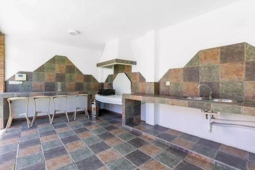 马拉加Ohana Luxury Villa with Heated Pool的厨房铺有瓷砖地板,设有带凳子的台面