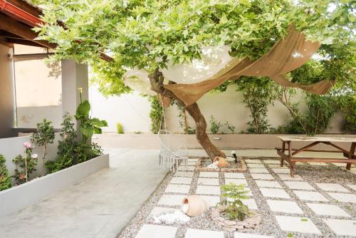 斯达林The 50/50 Luxury Apartments的一个带树和桌子的庭院