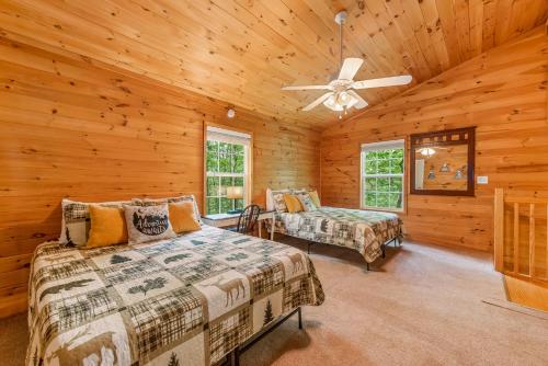 佩恩堡Serenity Escape Treehouse on 14 acres near Little River Canyon的小木屋卧室配有两张床和吊扇