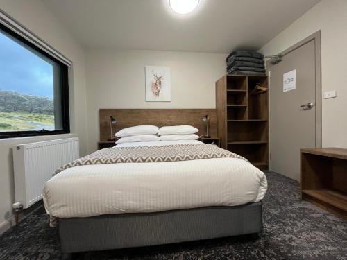 佩里舍峡谷流浪汉小屋酒店的一间卧室设有一张大床和一个窗户。