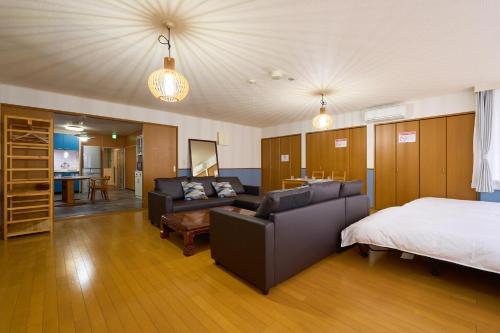 东京羽田雷克斯公寓的一间卧室配有一张床、一张床和一张沙发