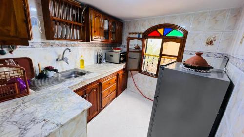 艾西拉Dar Yema的厨房配有冰箱和彩色玻璃窗