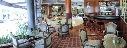 利马法拉奥纳大酒店的一间带桌椅的餐厅和一间酒吧