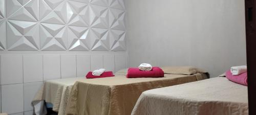MateirosPousada Status Jalapão的客房配有两张带粉红色枕头的床。