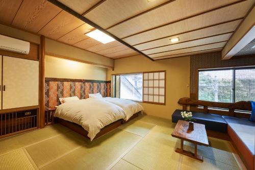 中之条Shima-Onsen Toshimaya的一间卧室配有一张大床和一张桌子