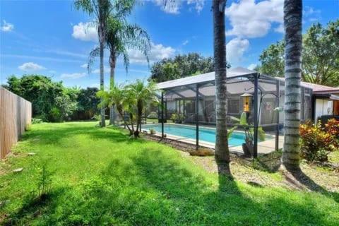 奥本代尔Florida Oasis的一座带游泳池和棕榈树的房子