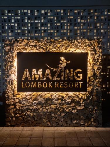 塞隆贝拉纳克Amazing Lombok Resort的夜间一个毫克大堂度假村的标志