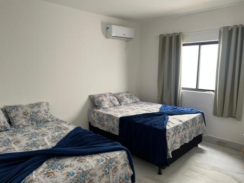 康德Carapibus casa de praia 02的一间卧室设有两张床和窗户。
