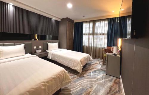 香港Hennessy Hotel的酒店客房配有两张床和一张书桌