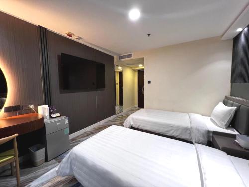 香港Hennessy Hotel的酒店客房设有两张床和一台平面电视。
