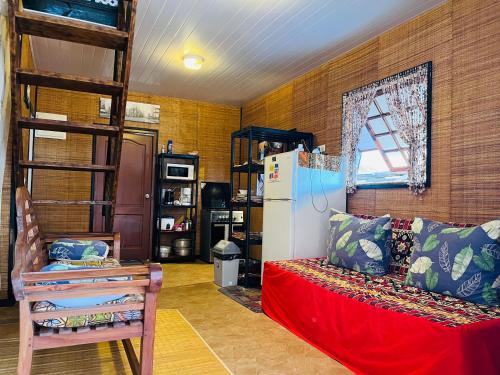 莫雷阿moorea temae bungalow lory bord de mer的客房设有冰箱、沙发和椅子。