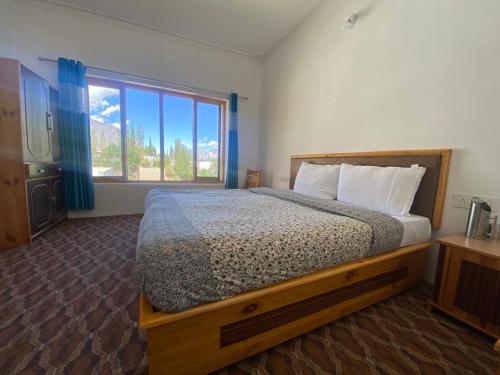 DeskitOtsal guest house nubra的一间卧室设有一张床和一个大窗户