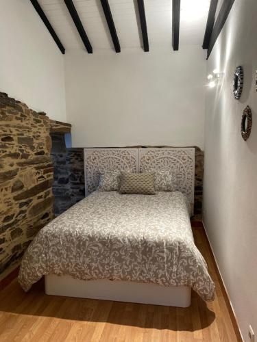 Casa do fundo do povo的一间卧室设有一张床和石墙