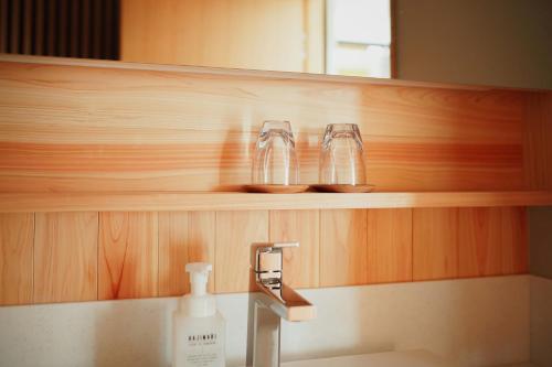 云仙市云仙新汤温泉日式旅馆的浴室设有水槽,架子上放着两杯玻璃