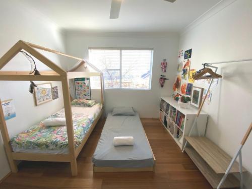 悉尼时尚宽敞海滩公寓的一间卧室配有双层床和书架