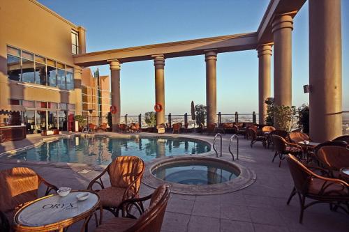 阿布扎比欧力克斯酒店的大楼内带桌椅的大型游泳池