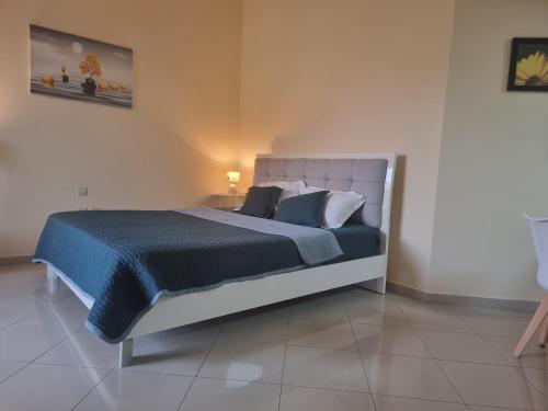 拉斯阿尔卡麦Nice Al Marjan studio的一间卧室配有一张大床,提供蓝色的床单和枕头