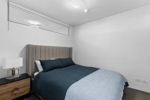 墨尔本Perfect Urban Retreat!的一间卧室配有一张带蓝色毯子的大床