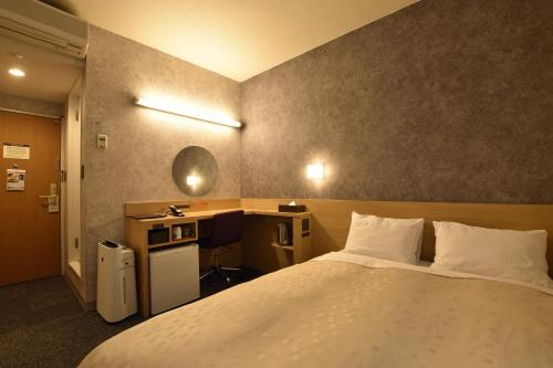 旭川旭川太阳酒店的酒店客房设有一张大床和一张书桌。